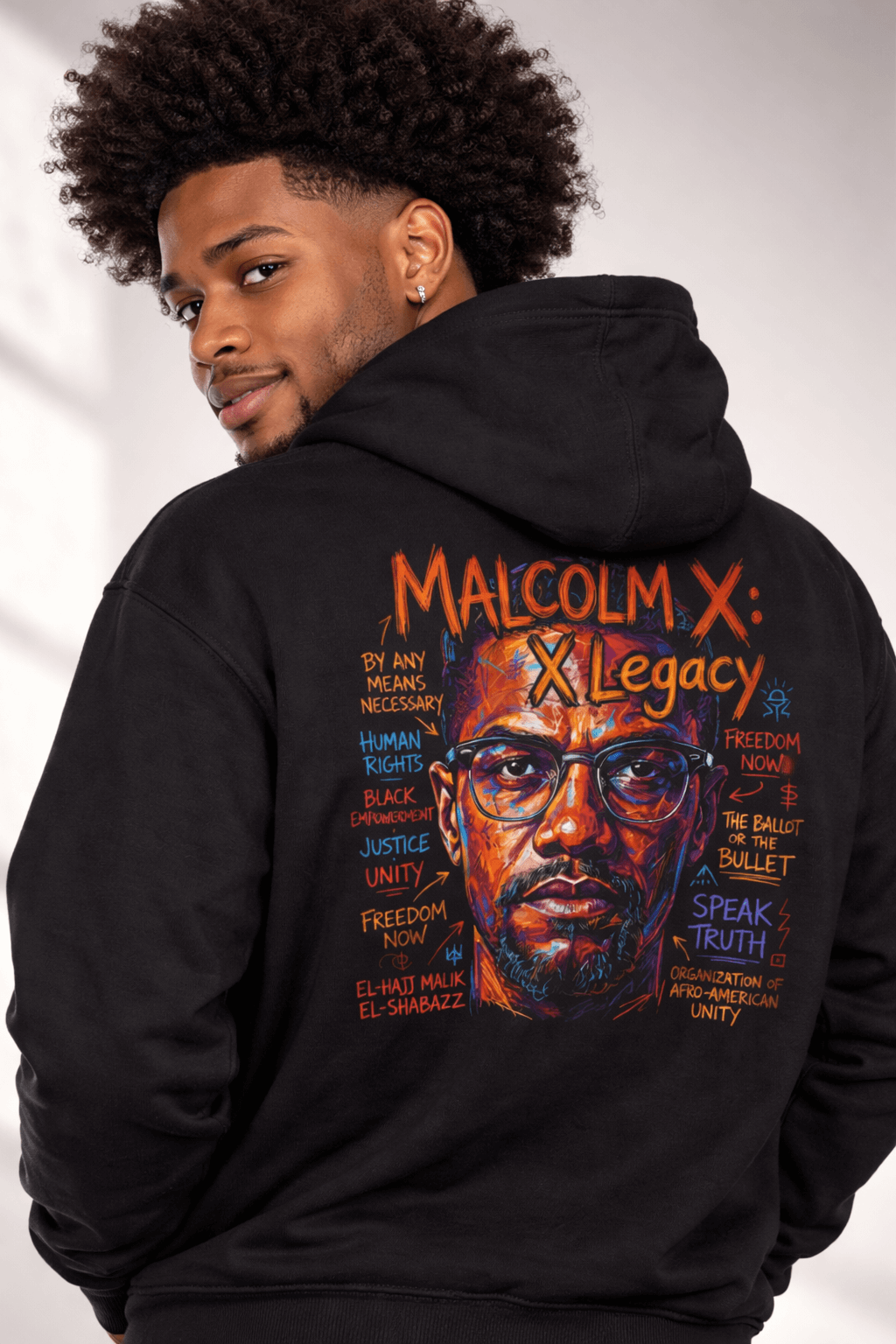 Model wearing a black X LEGACY hoodie featuring a colorful Malcolm X design and empowering text.