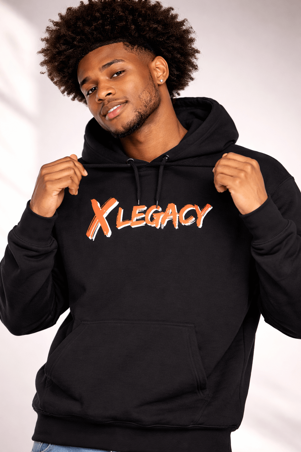 Model wearing the X LEGACY Hoodie in black, featuring a stylish logo and perfect for comfort and presence.